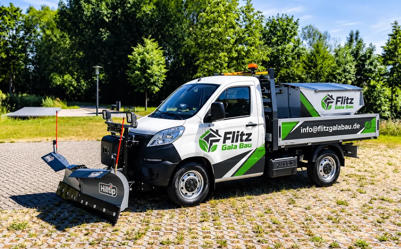 Flitz-Fahrzeug mit angebauter Kehrbürste auf einer gepflasterten Außenfläche